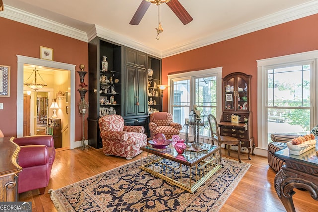 living area featuring a ceiling fan, crown molding, and light wood-style flooring