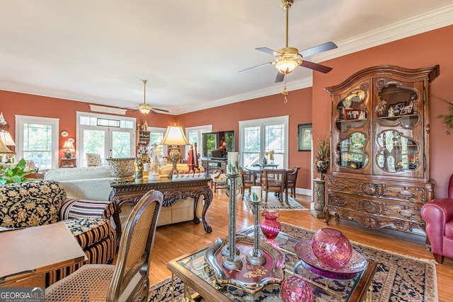 living room with light wood-style floors, a wealth of natural light, and crown molding