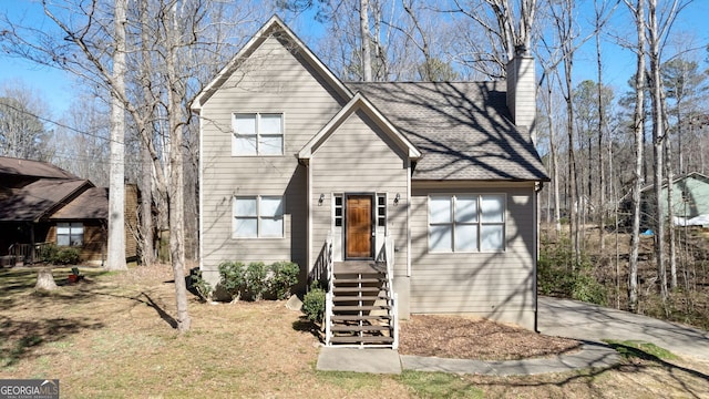 view of front of house featuring a front lawn and a chimney