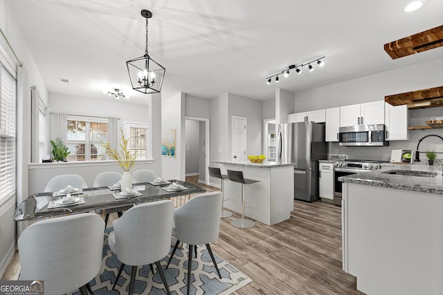 dining space featuring light wood-style floors, baseboards, and a chandelier