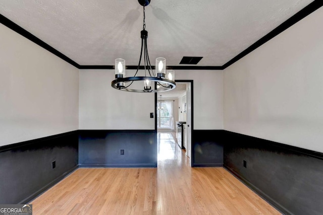 interior space with ornamental molding, wainscoting, and wood finished floors