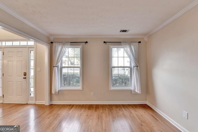 foyer entrance featuring plenty of natural light, wood finished floors, visible vents, and baseboards