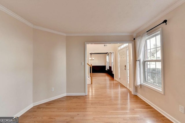 interior space with baseboards, ornamental molding, and light wood-style floors