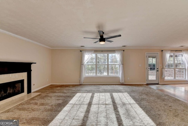 unfurnished living room featuring baseboards, carpet, a fireplace with flush hearth, and crown molding