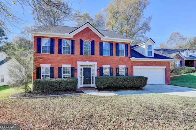 colonial-style house with driveway, brick siding, an attached garage, and a front yard