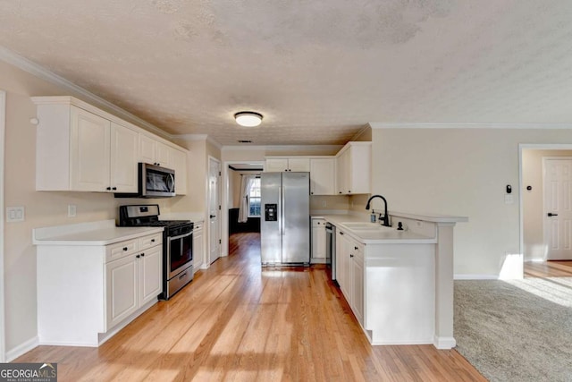 kitchen with stainless steel appliances, light countertops, light wood-type flooring, white cabinetry, and a sink