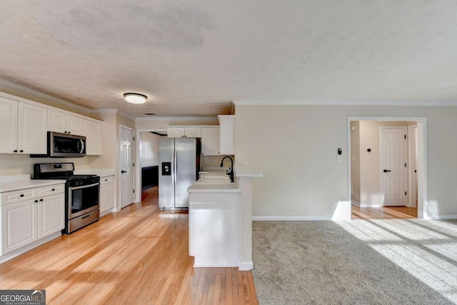 kitchen with baseboards, white cabinetry, stainless steel appliances, and crown molding