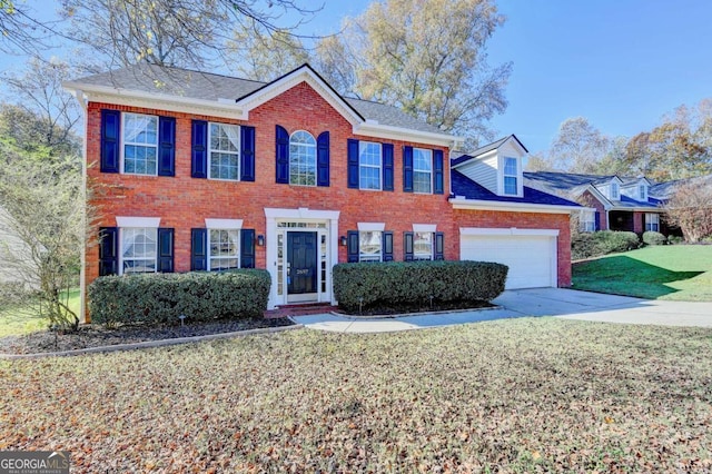 colonial-style house featuring an attached garage, concrete driveway, brick siding, and a front yard