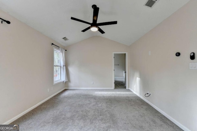 carpeted spare room featuring lofted ceiling, baseboards, visible vents, and a ceiling fan