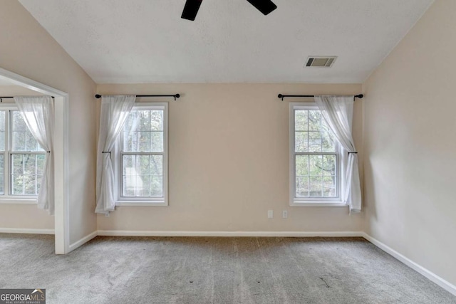 unfurnished room with carpet floors, visible vents, and baseboards