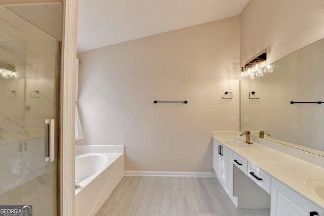 bathroom with a sink, baseboards, a shower stall, a bath, and double vanity