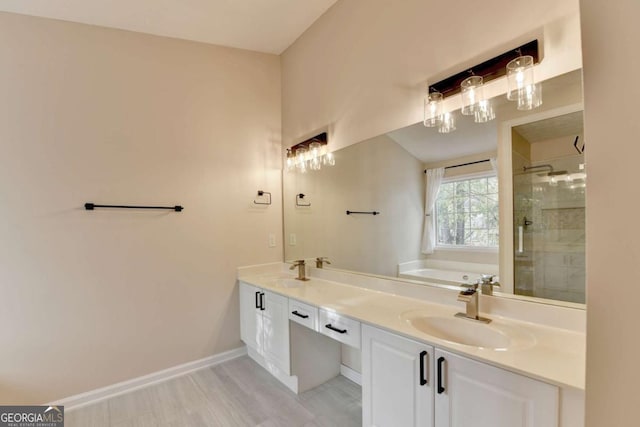 bathroom with a garden tub, a sink, a shower stall, and baseboards