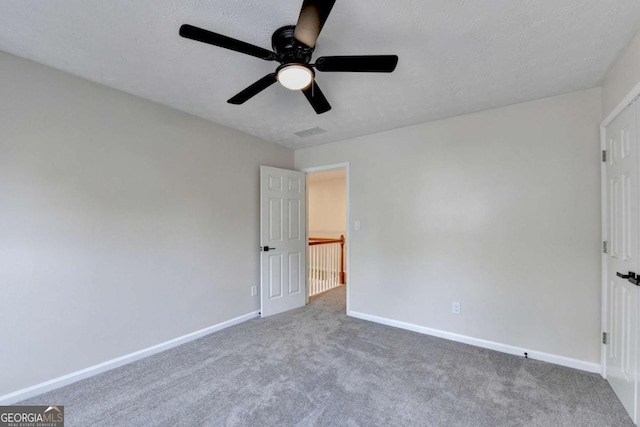 unfurnished bedroom with visible vents, baseboards, a ceiling fan, a textured ceiling, and carpet floors