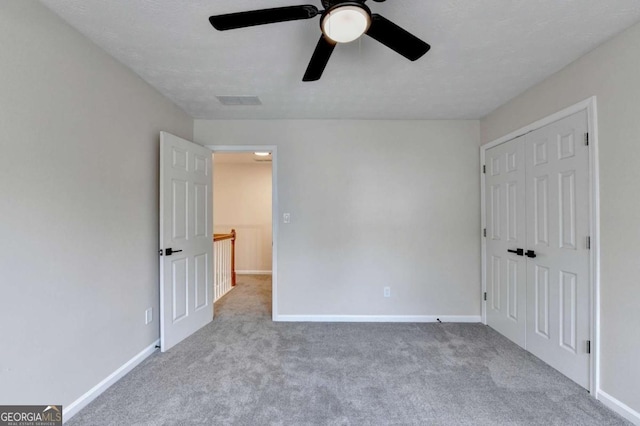 unfurnished bedroom featuring visible vents, baseboards, a ceiling fan, carpet floors, and a closet