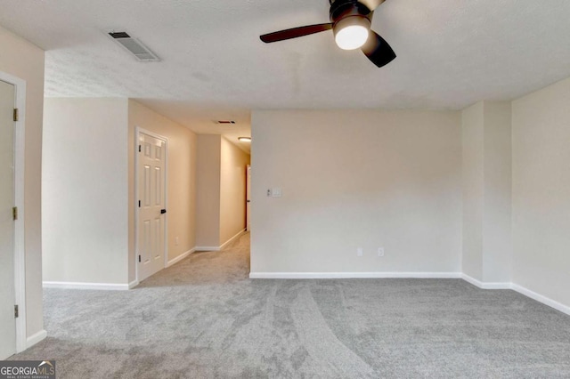 spare room featuring a ceiling fan, carpet flooring, visible vents, and baseboards