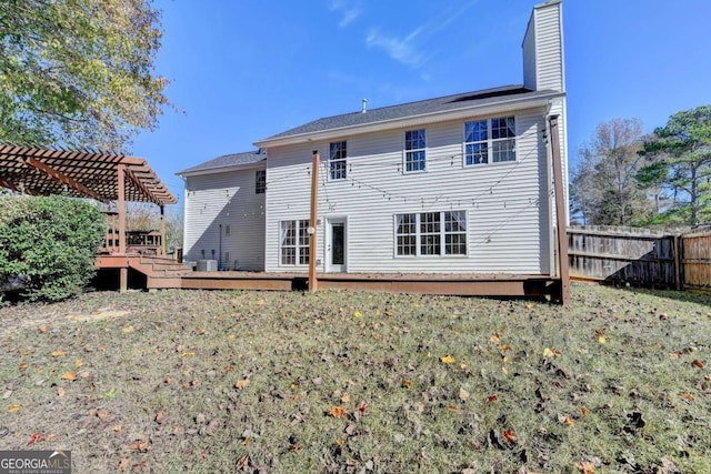 rear view of property with fence, a chimney, a wooden deck, and a pergola