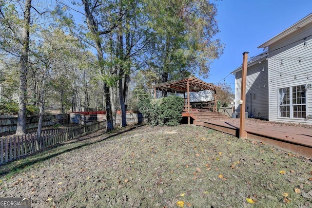 view of yard featuring a deck, fence, and a pergola