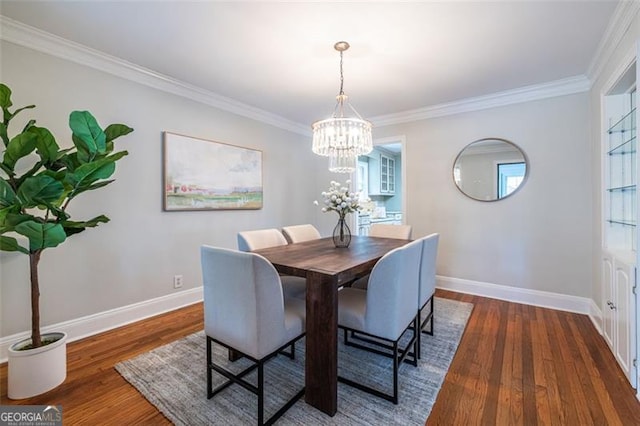 dining area featuring a chandelier, crown molding, baseboards, and wood finished floors