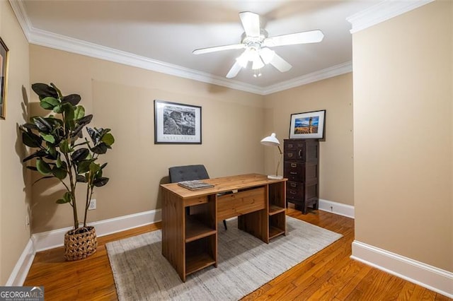 office area featuring baseboards, light wood finished floors, a ceiling fan, and crown molding