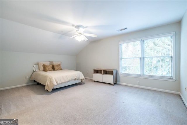 carpeted bedroom with lofted ceiling, a ceiling fan, visible vents, and baseboards