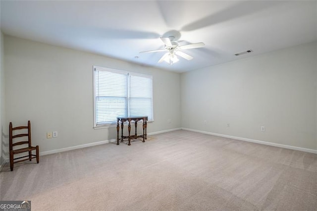 unfurnished room with visible vents, ceiling fan, light carpet, and baseboards