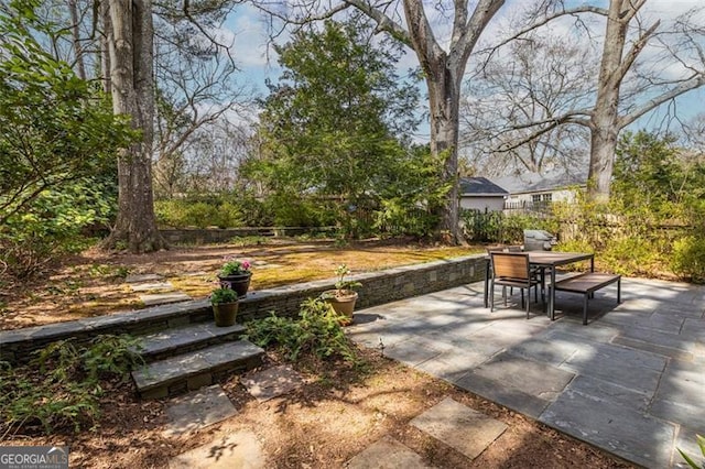 view of patio with outdoor dining space and fence