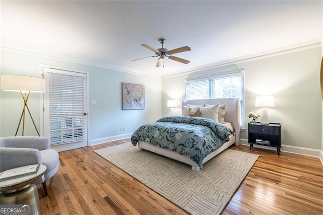 bedroom featuring ornamental molding, a ceiling fan, baseboards, and wood finished floors