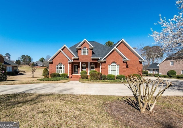 traditional-style house featuring brick siding and a front lawn