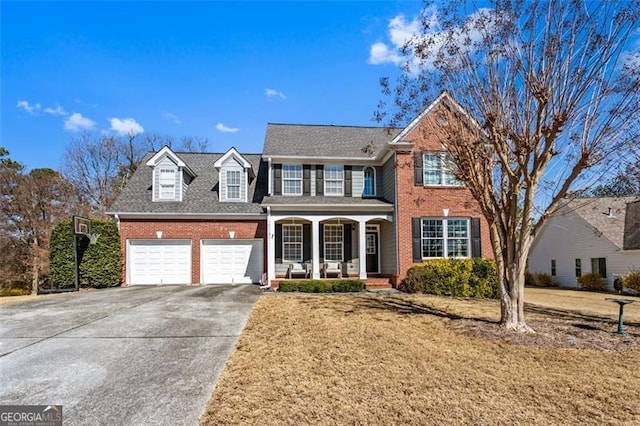 view of front of property featuring an attached garage, covered porch, brick siding, driveway, and a front yard