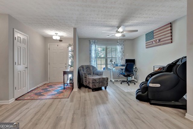 interior space with a textured ceiling, baseboards, and wood finished floors