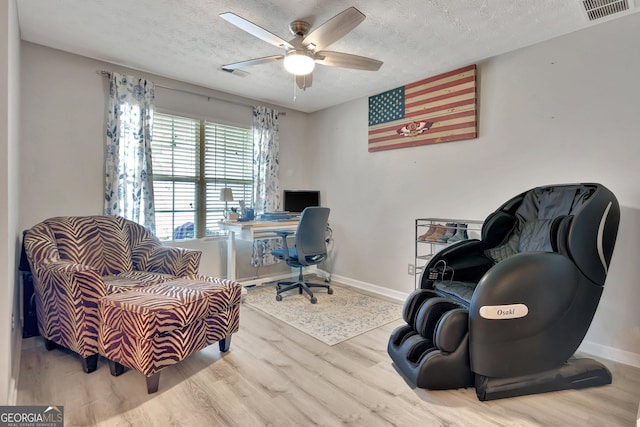 home office with baseboards, visible vents, a textured ceiling, and wood finished floors