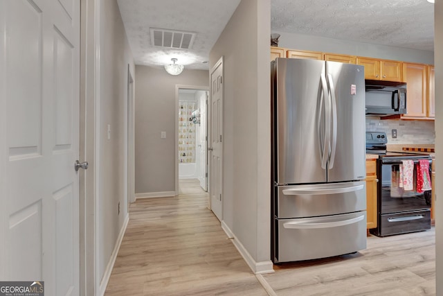 kitchen featuring light wood-type flooring, visible vents, black appliances, and light brown cabinetry