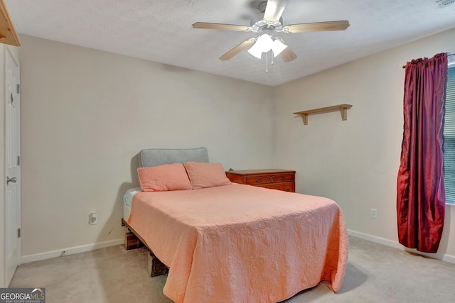 bedroom with ceiling fan, baseboards, and light colored carpet