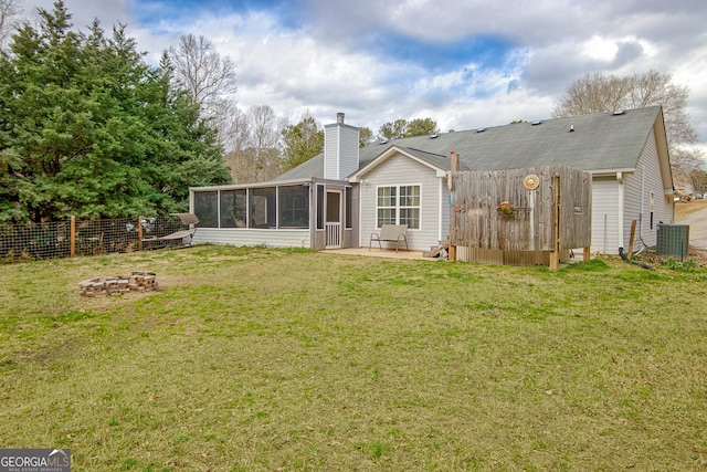 back of property featuring a sunroom, a chimney, fence, a yard, and central air condition unit