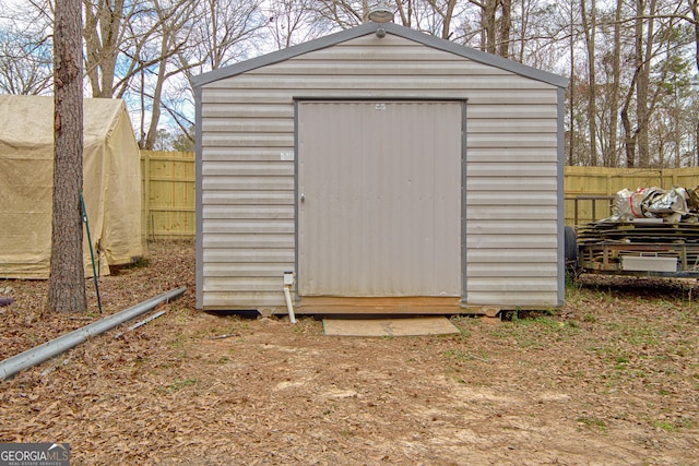 view of shed featuring fence