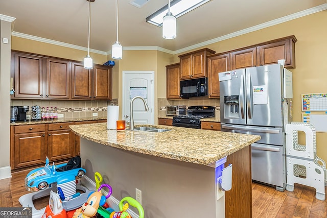 kitchen featuring black appliances, light wood finished floors, a sink, and light stone counters