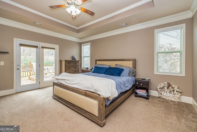 bedroom with access to exterior, a raised ceiling, visible vents, and carpet flooring