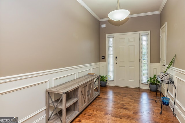 entryway with a wainscoted wall, ornamental molding, a decorative wall, and dark wood-type flooring