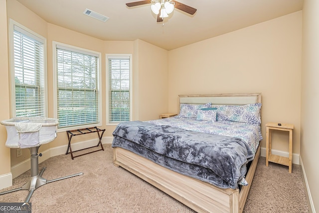 bedroom featuring carpet, visible vents, baseboards, and multiple windows