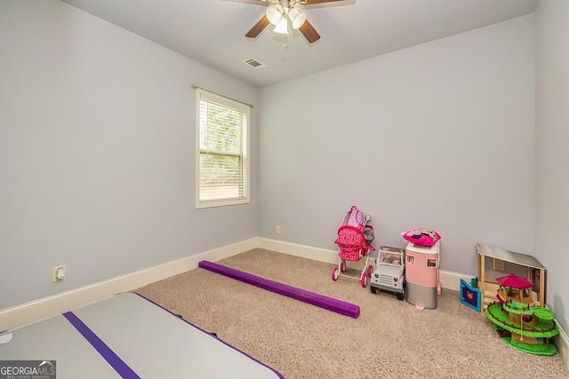 recreation room with carpet floors, visible vents, baseboards, and ceiling fan