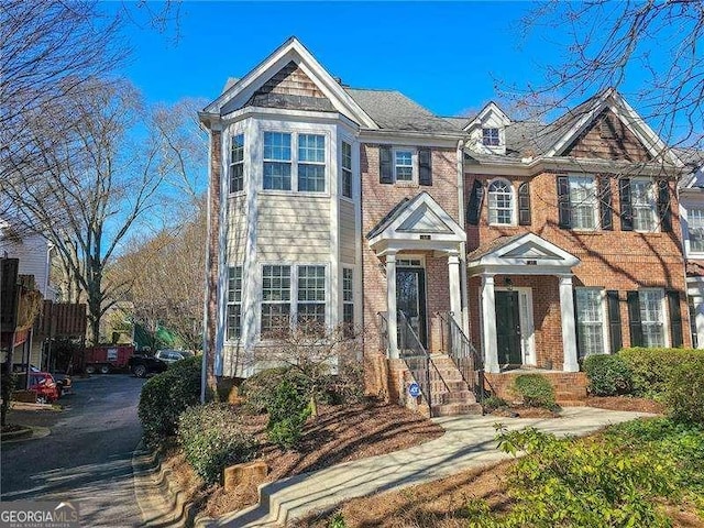 view of front of home with brick siding and fence