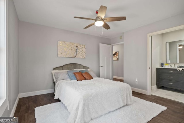 bedroom with a sink, baseboards, and wood finished floors