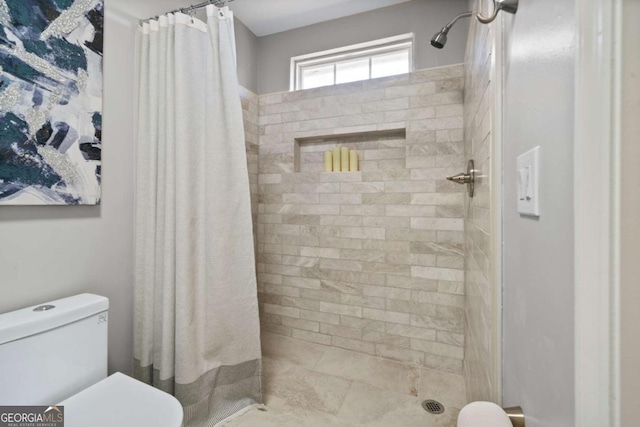 bathroom with a shower stall and toilet