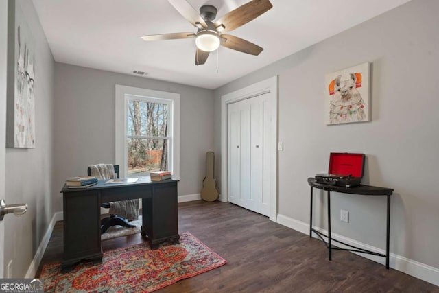 office space with visible vents, a ceiling fan, baseboards, and wood finished floors