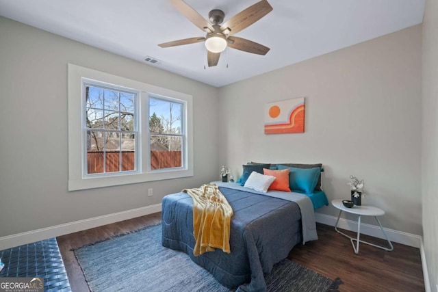 bedroom featuring visible vents, baseboards, and wood finished floors