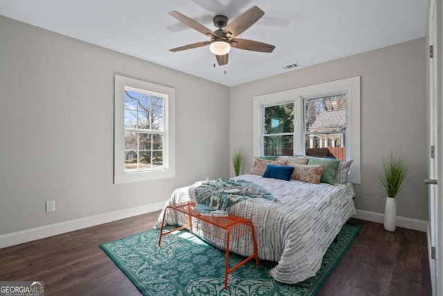 bedroom featuring visible vents, baseboards, wood finished floors, and a ceiling fan