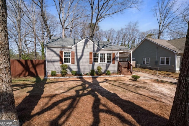 view of front of house featuring driveway and fence