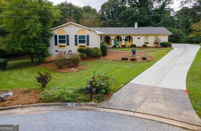 ranch-style house featuring a front yard and decorative driveway