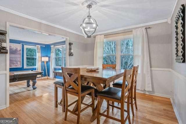 dining area featuring ornamental molding, light wood-style floors, and baseboards