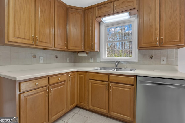 kitchen with dishwasher, light countertops, light tile patterned floors, and a sink